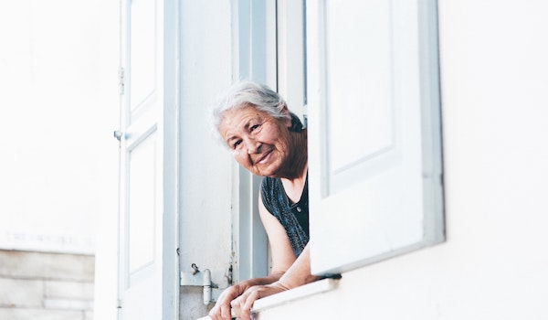 smiling woman peeking out a window