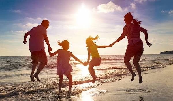 family jumping on beach